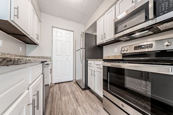 A kitchen with black appliances and white cabinets.